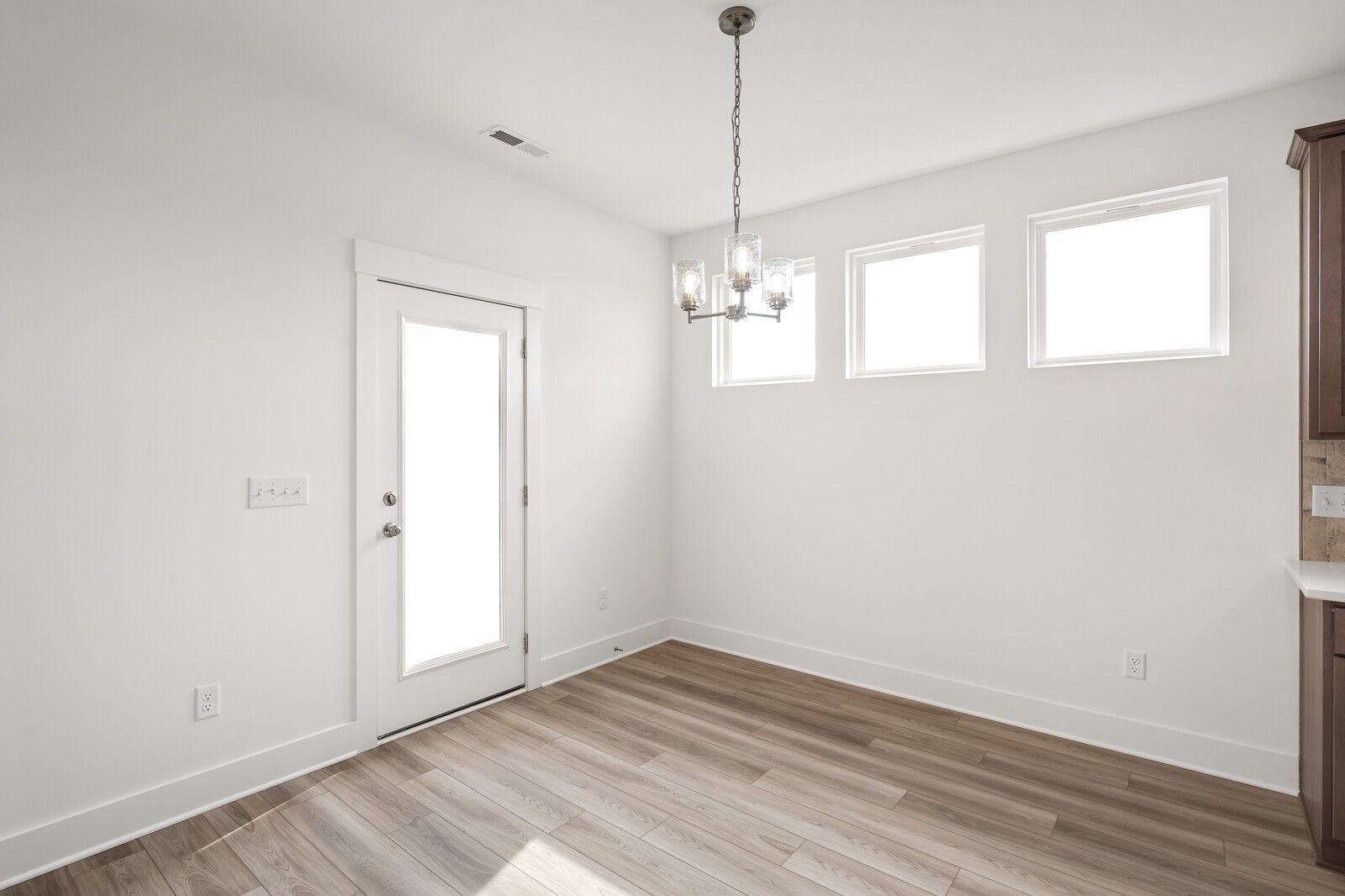 White butler's pantry with shaker cabinets, farmhouse sink, chandelier, and windows in Davidson Homes The Ash C, Mt. Juliet
