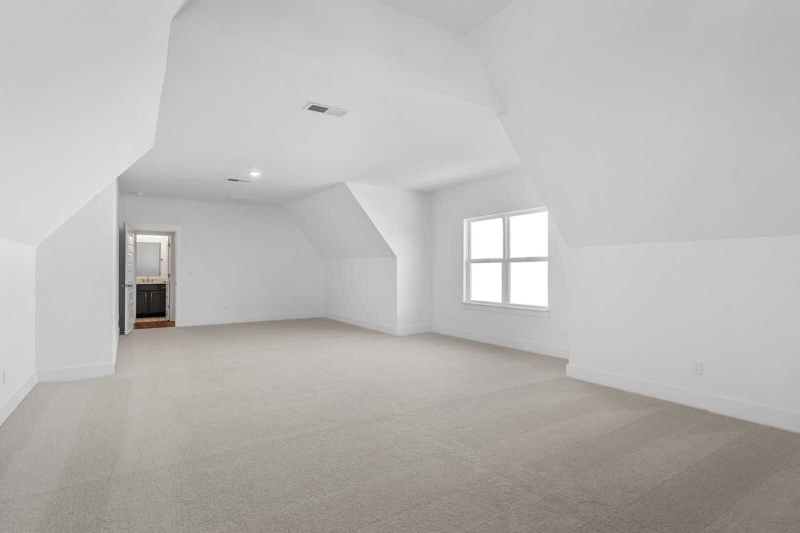 Bright upstairs bedroom with vaulted ceilings, large windows, and en-suite bath access in Davidson Homes The Hawkins, Murfreesboro