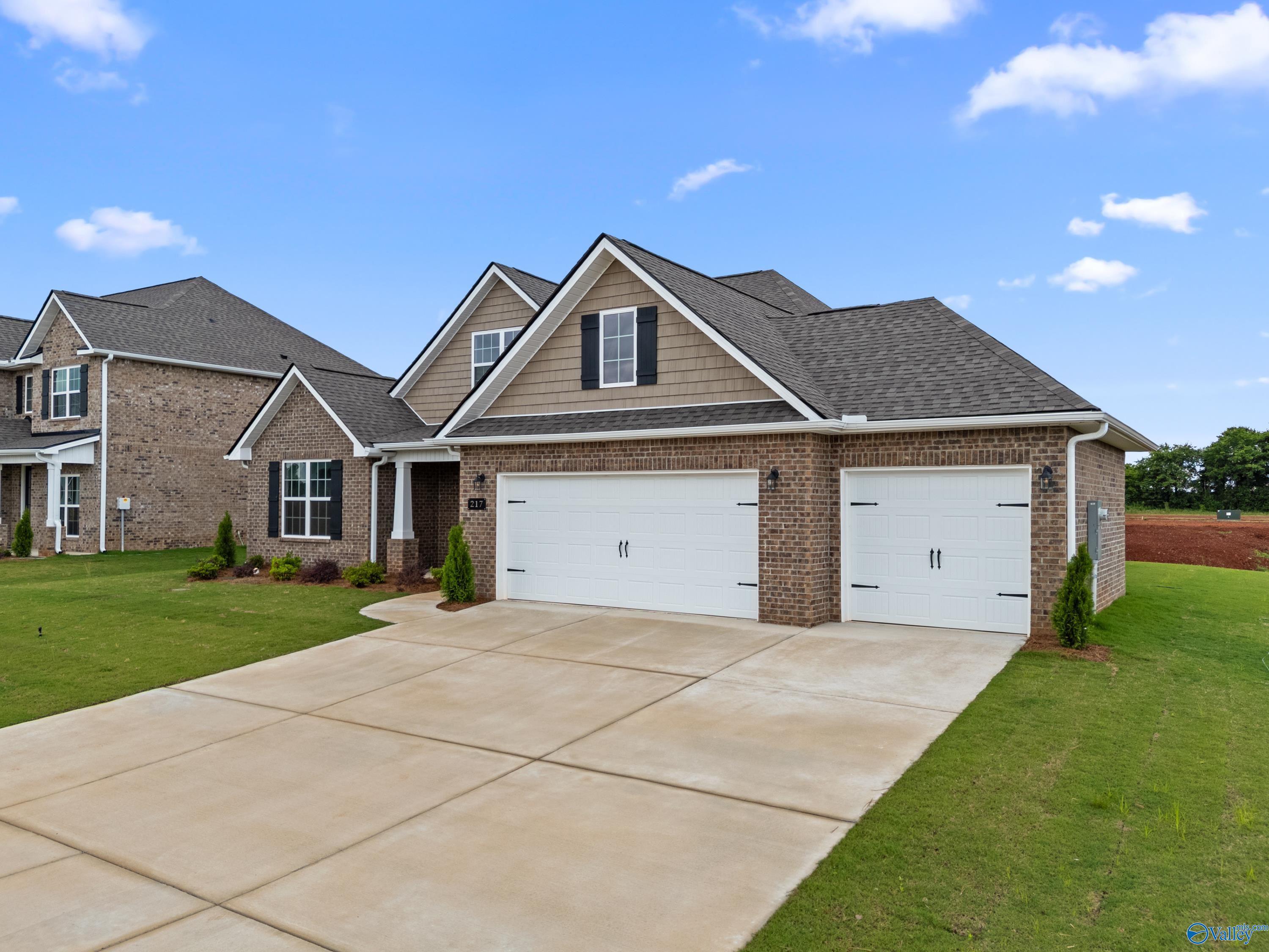 Davidson Homes The Rockford B ranch: brick facade, 3-car garage, manicured lawn in Kendall Farms, Toney, Alabama