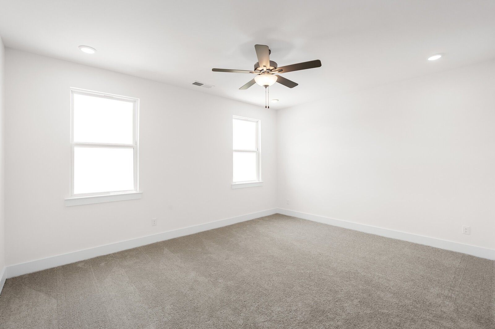 Bright, carpeted bedroom with ceiling fan in The Cottonwood E floor plan at Woods Crossing, Gallatin, Tennessee.