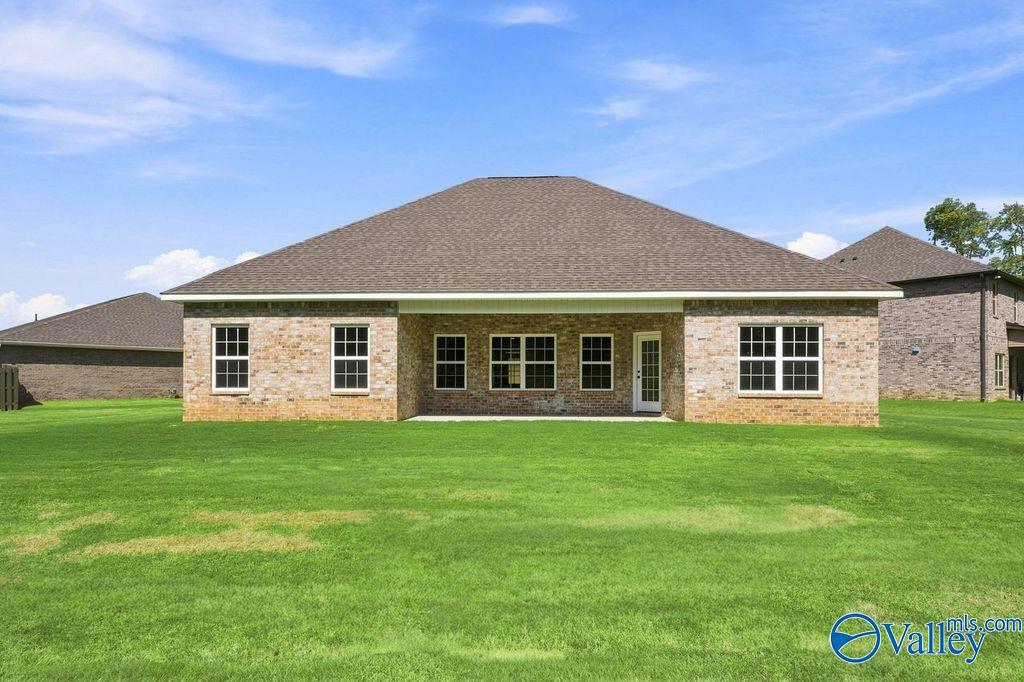Brick rear exterior with covered patio and large fenced yard in Davidson Homes' The Rockford, Cain Park, Hartselle, Alabama