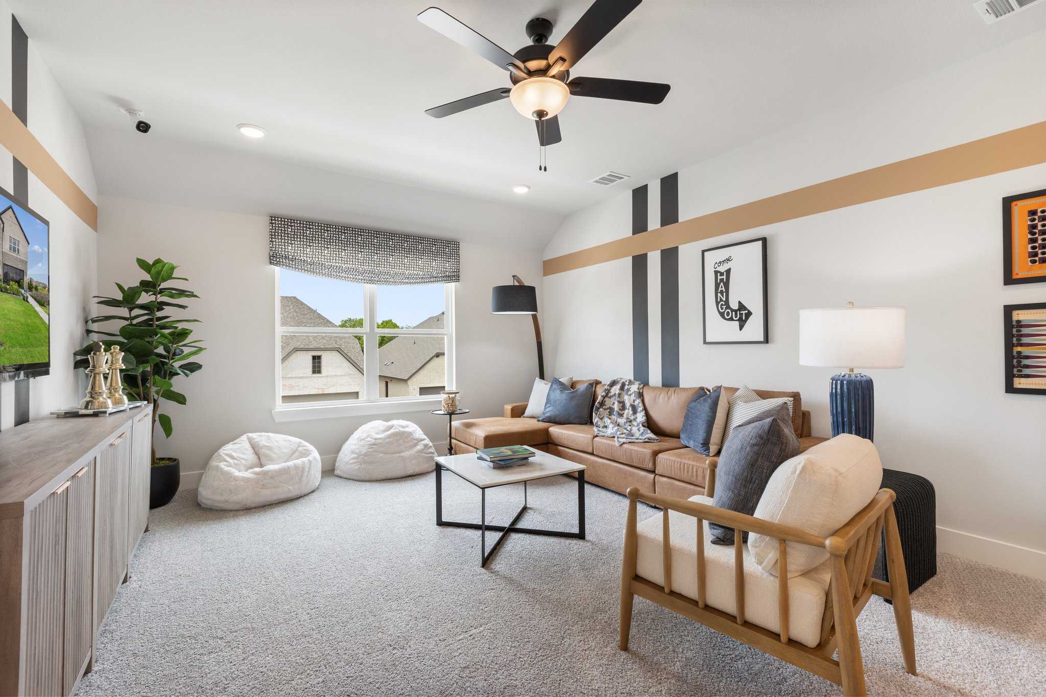 Cozy media room at Mercer Meadows in Royse City TX by Davidson Homes featuring ceiling fan plush sofa bean bags wall TV
