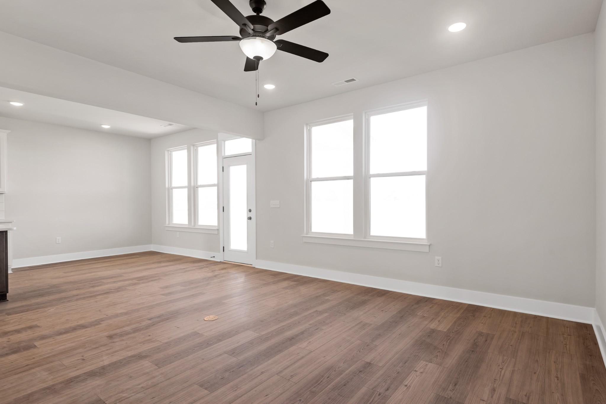 Bright open living room with hardwood floors, ceiling fan, and large windows in Davidson Homes The Willow B, Calista Farms, White House, TN