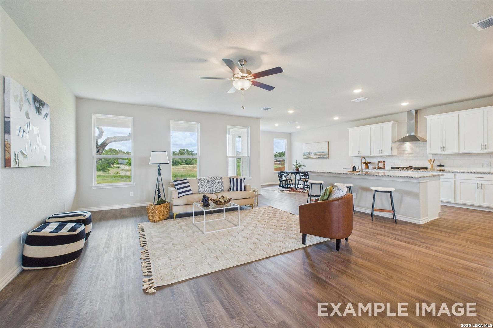 Open-concept living room and kitchen in The Foster F floor plan at Potranco Oaks, Castroville, Texas.