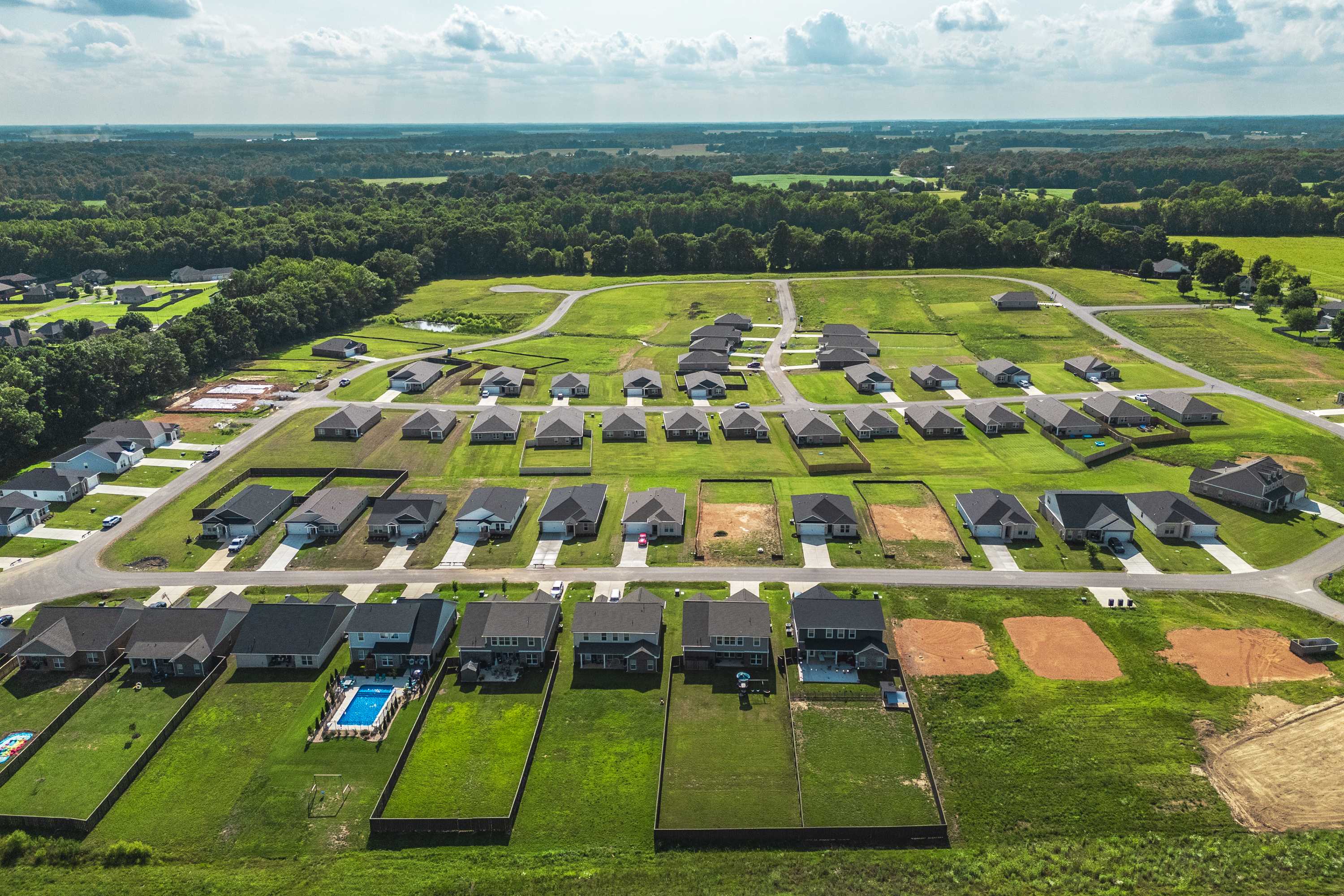 Aerial view of Bailey Park in Fayetteville TN showcasing new Davidson Homes, green lawns, inground pool, and wooded surroundings