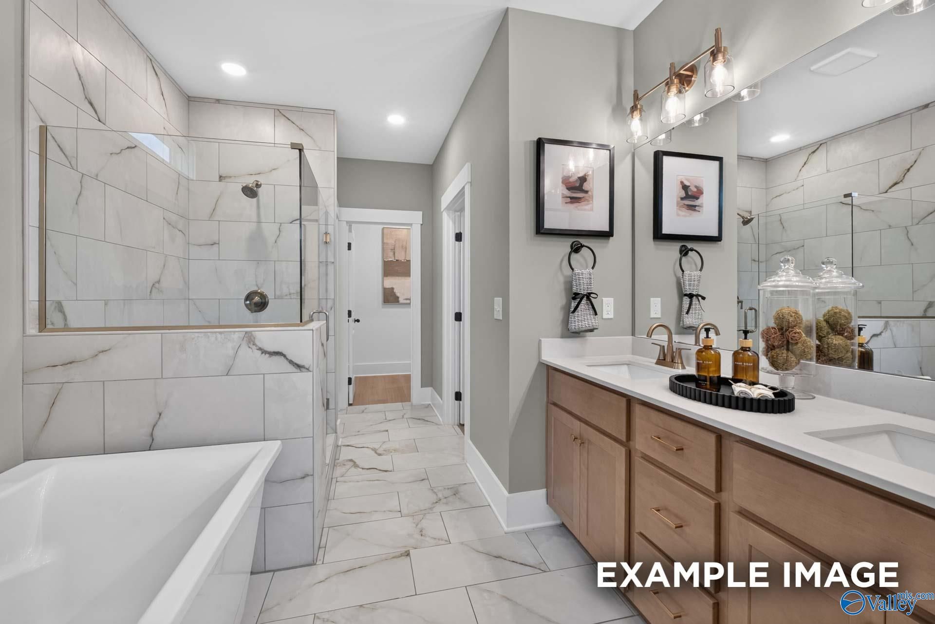 Master bathroom with marble tile walk-in shower, soaking tub, and dual vanity in Davidson Homes Ashport K, Hazel Green, Alabama