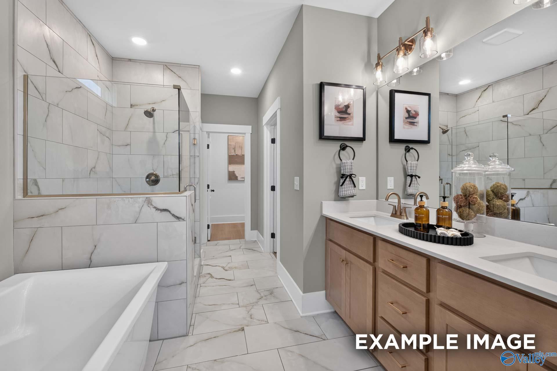 Master bathroom with marble tile walk-in shower, soaking tub, and dual vanity in Davidson Homes Ashport K, Hazel Green, Alabama