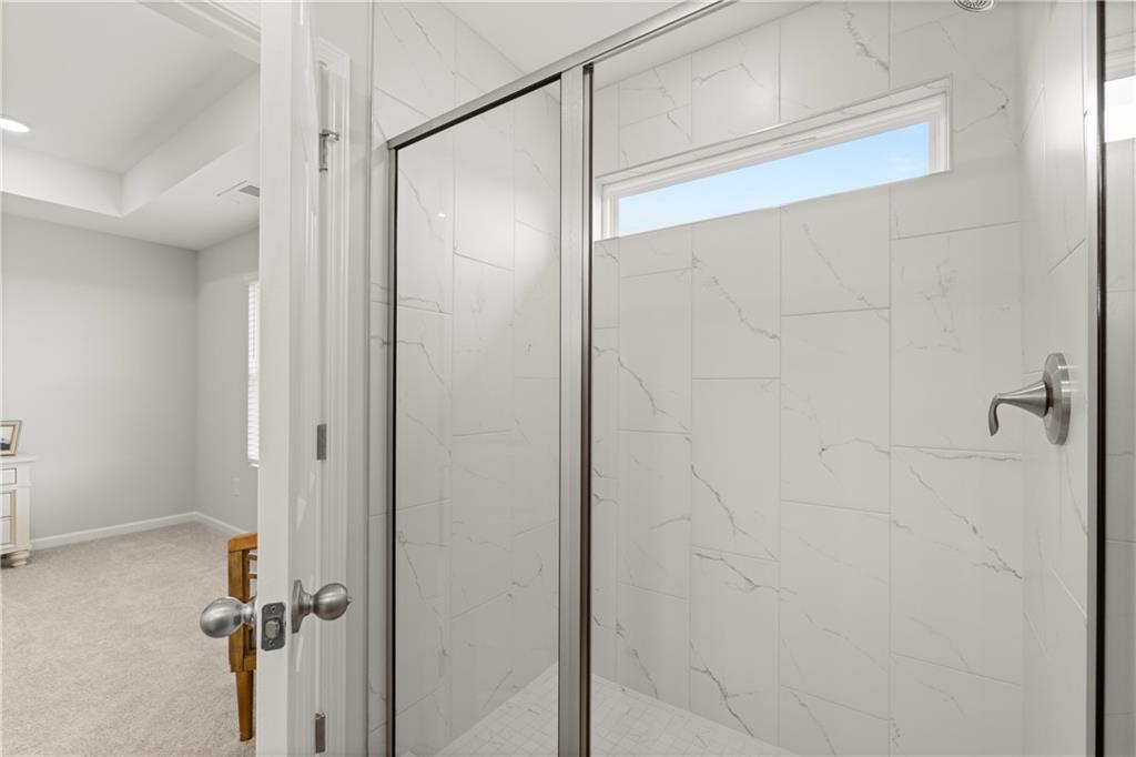 Modern walk-in shower with white marble-style tile in The Wake G floor plan at Hemingway in Cumming, Georgia.