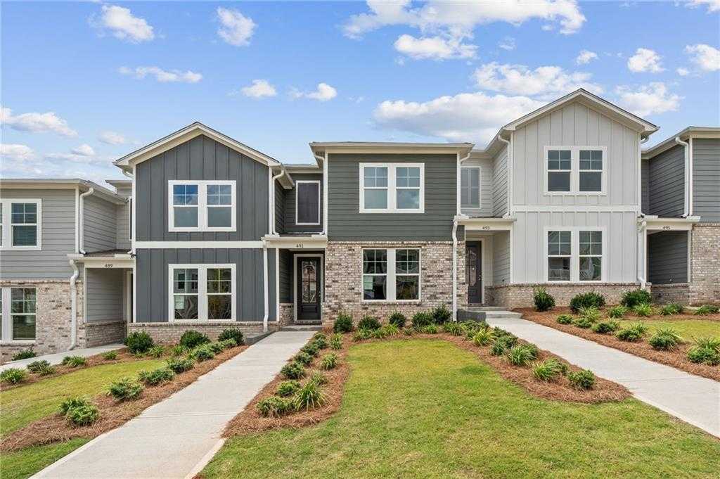 Modern two-story townhomes with gray siding, brick accents, front porches, and landscaped yards in Stegall Village, Emerson, GA
