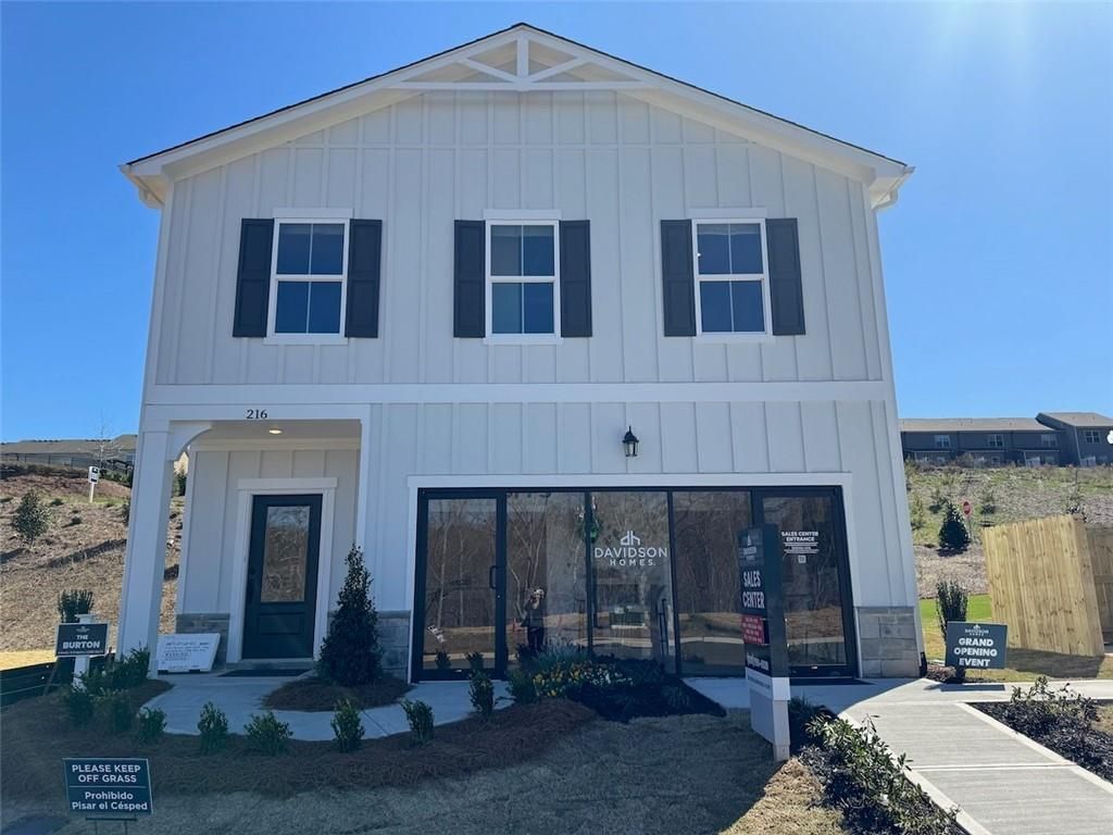 White craftsman two-story home with front porch, garage, and for-sale sign in The Bluffs, Canton, Georgia by Davidson Homes The Hartwell A