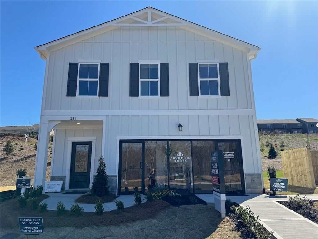 White craftsman two-story home with front porch, garage, and for-sale sign in The Bluffs, Canton, Georgia by Davidson Homes The Hartwell A