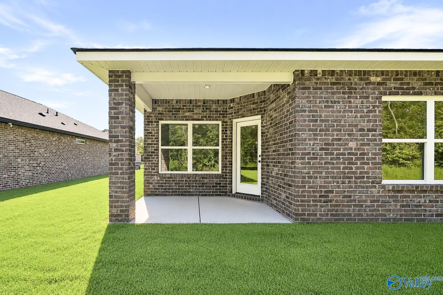 Covered brick patio and private backyard of The Daphne floor plan by Davidson Homes in Spragins Cove, Huntsville, Alabama.