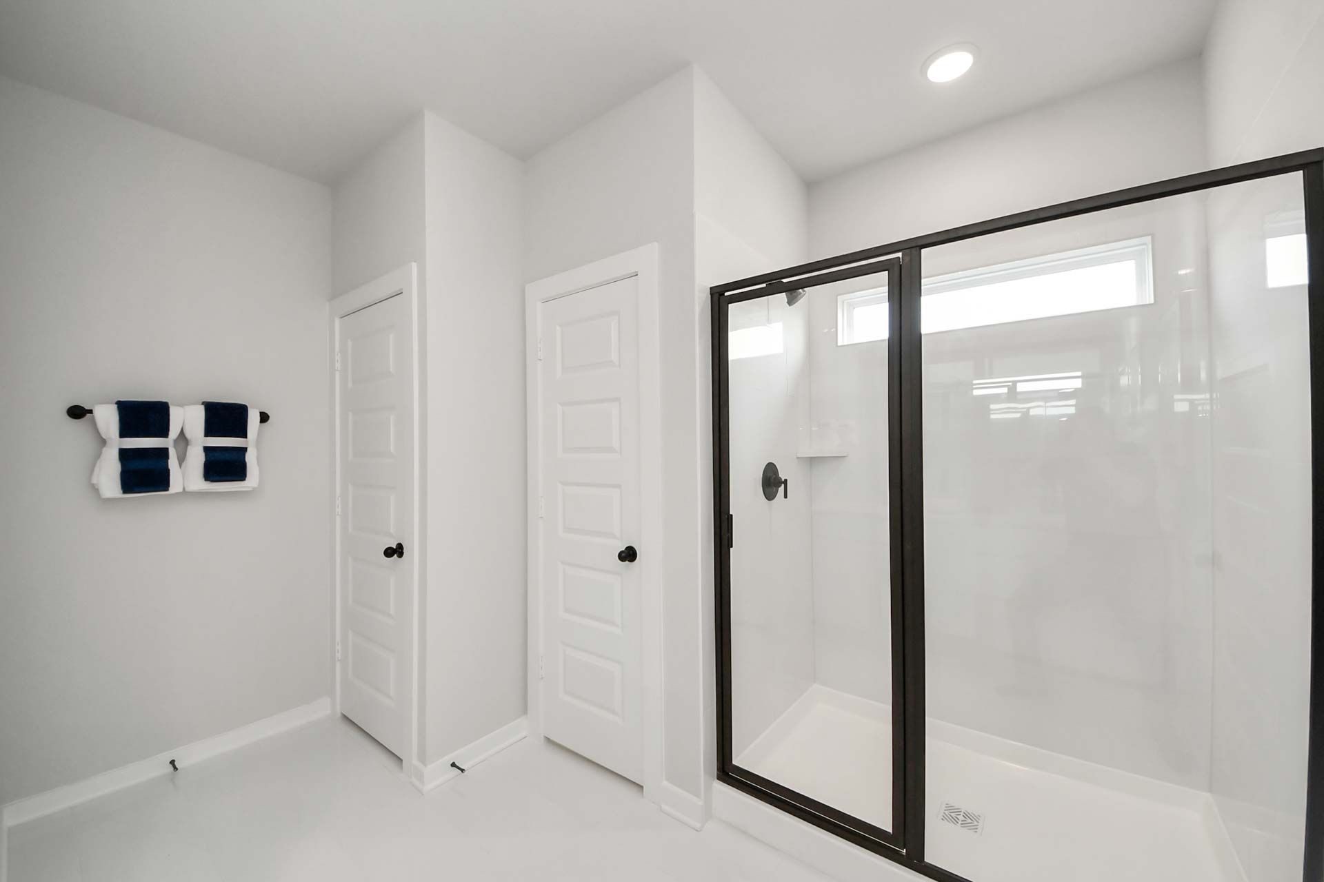 Modern bathroom with walk-in glass shower and black fixtures at Enclave at Newport in Crosby, Texas by Davidson Homes