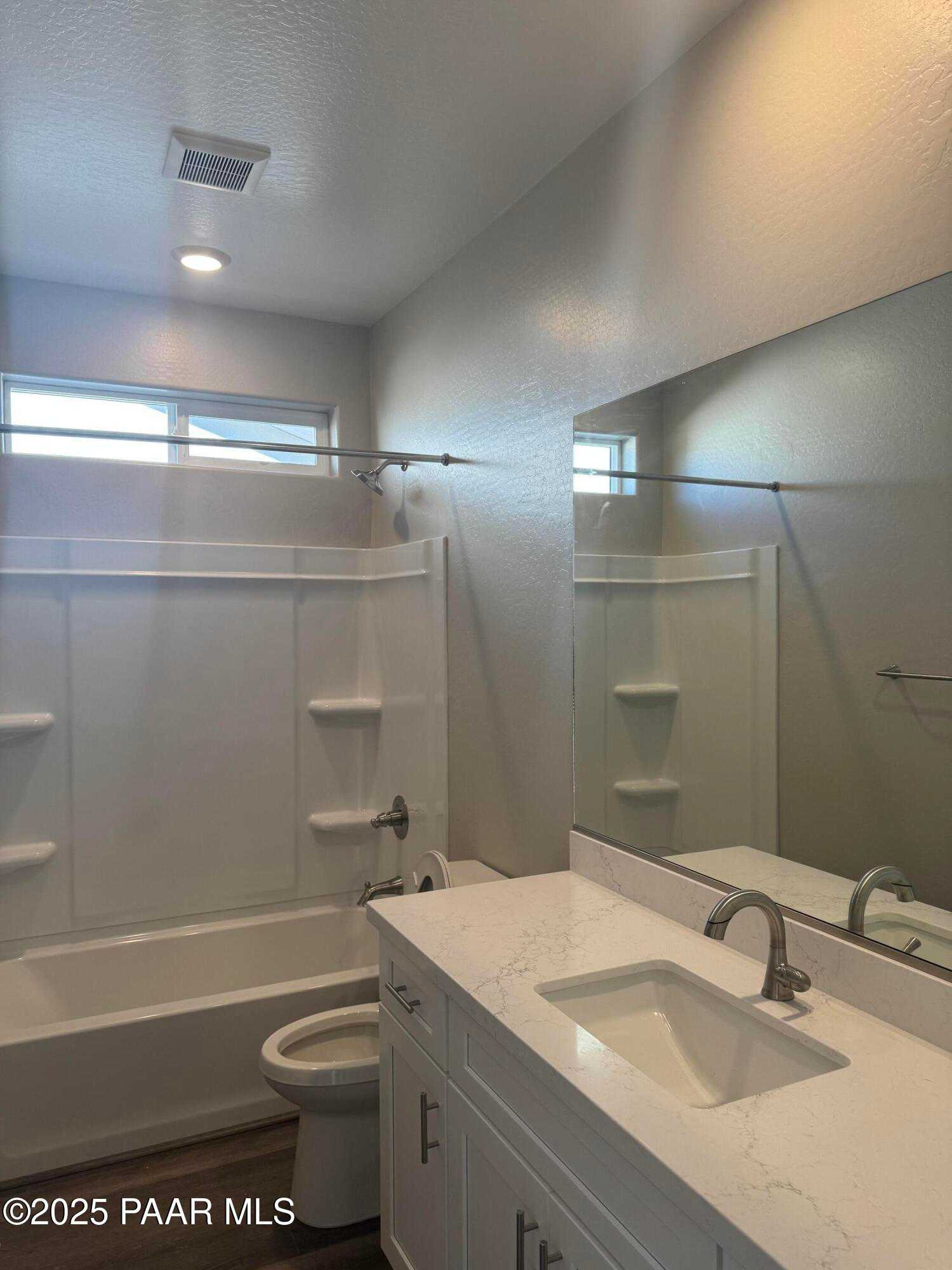 Modern master bathroom with white quartz vanity, soaking tub, walk-in shower in Davidson Homes The Monarch E, Prescott, AZ