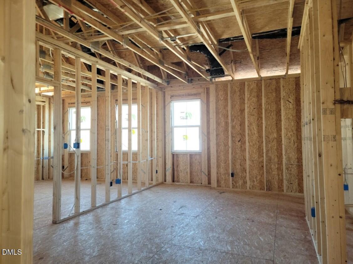 Unfinished interior framing with exposed joists and windows in 5-bedroom Ashport G home, Davidson Homes, Angier NC