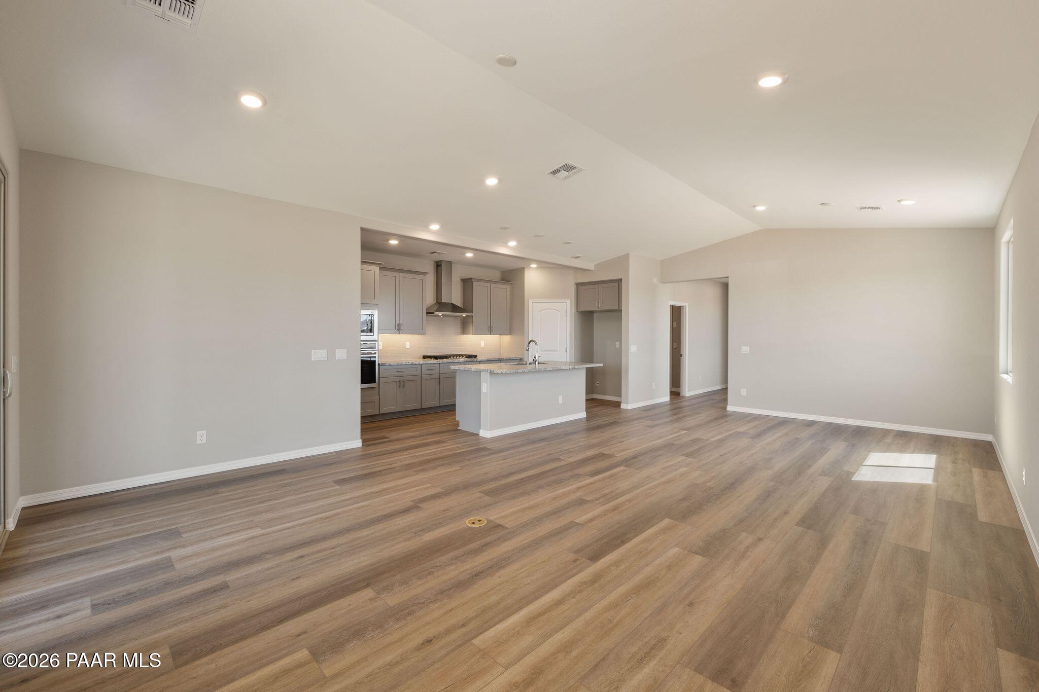 Open-concept living room and kitchen with island, hardwood floors, and neutral tones in Davidson Homes The Frontier A, Prescott Valley, AZ
