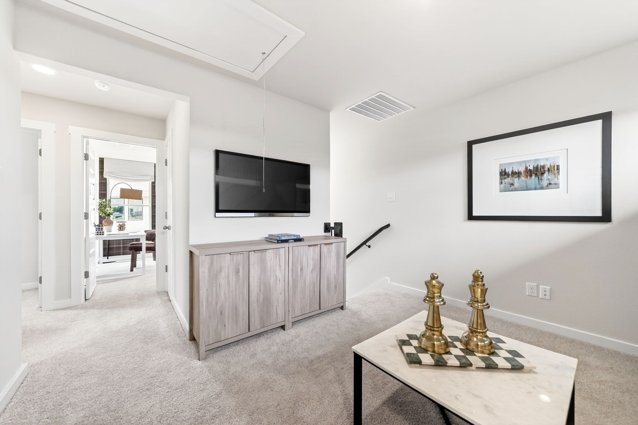 Cozy loft living area at Mesa Vista in San Antonio with wall-mounted TV, wooden console, and modern decor.