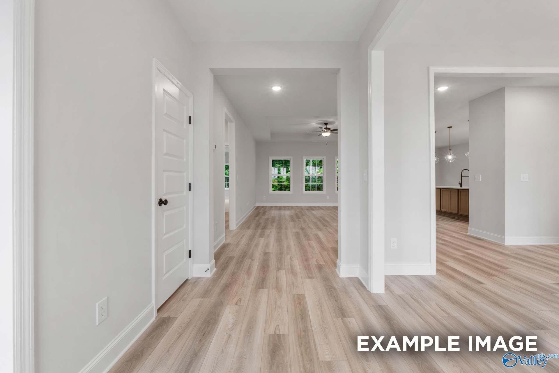 Bright hallway with light wood floors leading to open kitchen in Davidson Homes The Finleigh, Meridianville, Alabama
