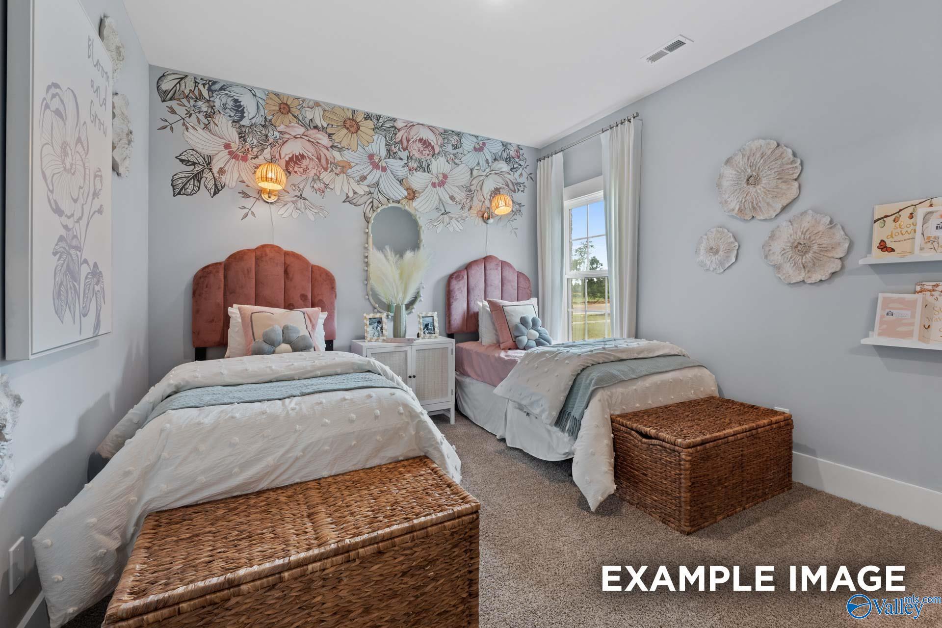 Cozy children's bedroom with twin beds, pink headboards, floral wallpaper, and decorative shelves in Davidson Homes The Finleigh, Huntsville AL