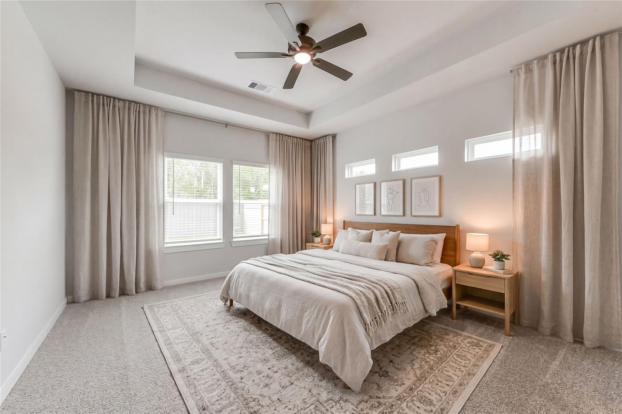 Serene master bedroom with king bed, neutral linens, sheer beige curtains, ceiling fan in Davidson Homes The Everett C, Crosby, Texas