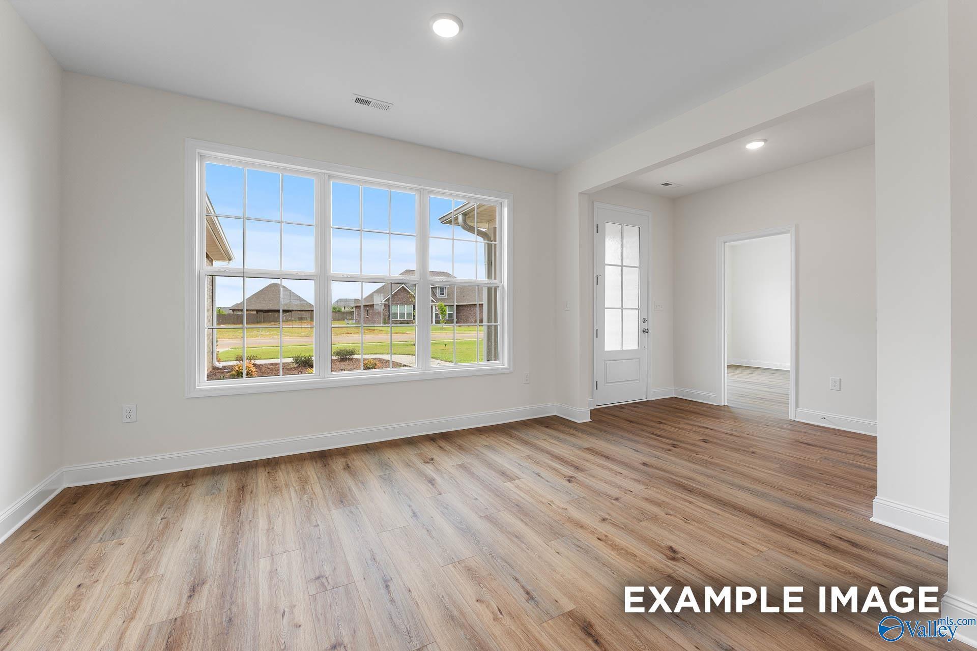 Bright living room with hardwood floors, large windows overlooking backyard in Davidson Homes The Emory, Toney, Alabama
