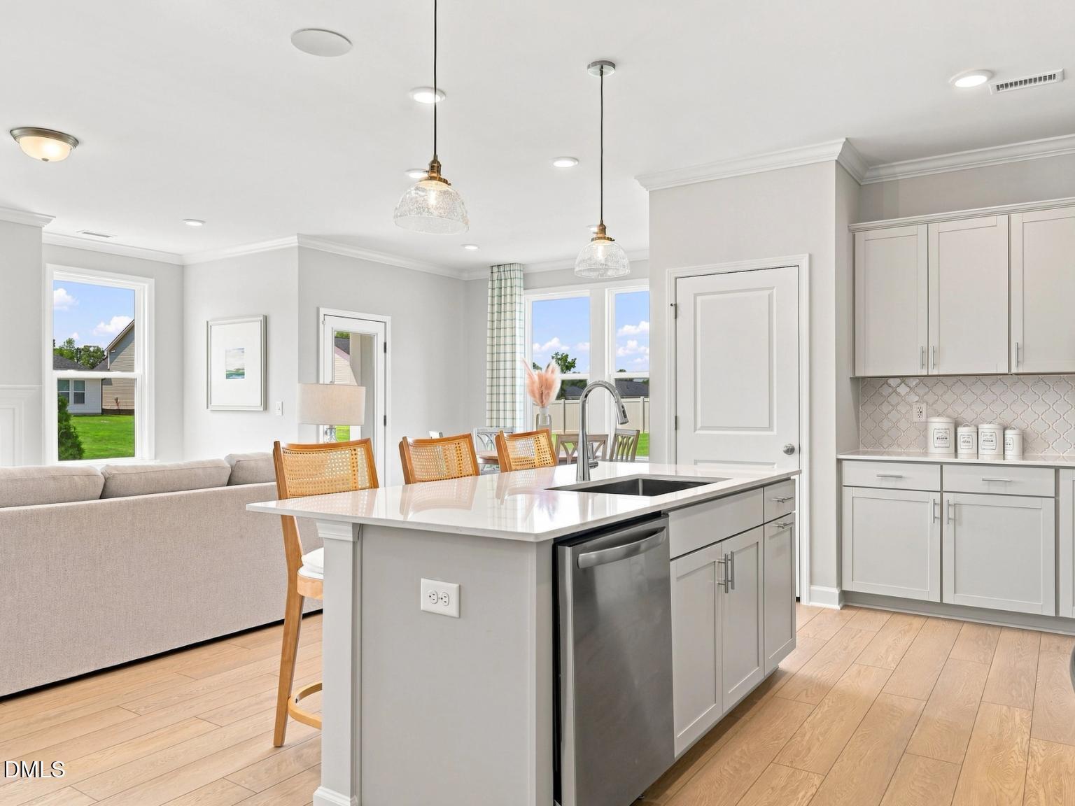 Modern kitchen with island and pendant lighting in The Daphne C floor plan at Woodland Crossing, Zebulon, North Carolina.