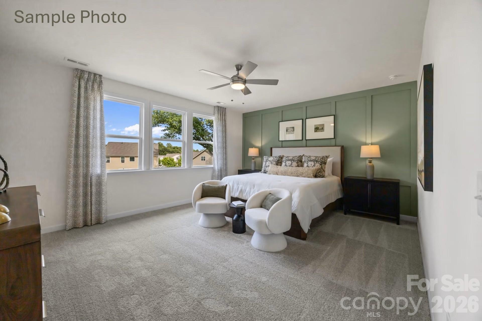 Spacious primary bedroom with sage green accent wall in The Beech B floor plan at Enclave at Belmont, North Carolina.