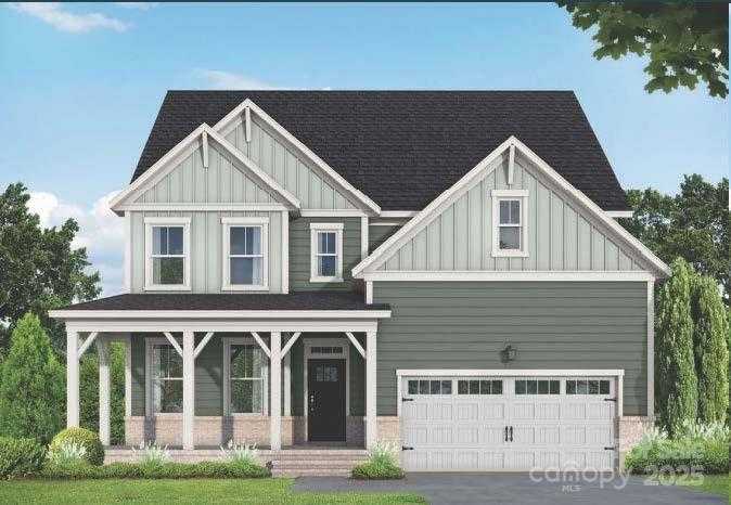 Two-story craftsman-style home with gray siding, black roof, covered front porch, and two-car garage in Enclave at Belmont, NC