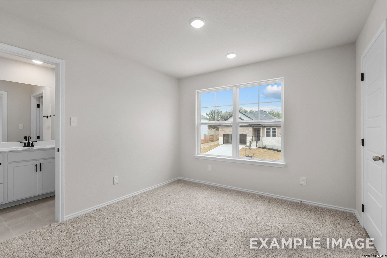 Bright bedroom with en-suite bathroom in The Sequoia C floor plan at Royal Crest, San Antonio, Texas.