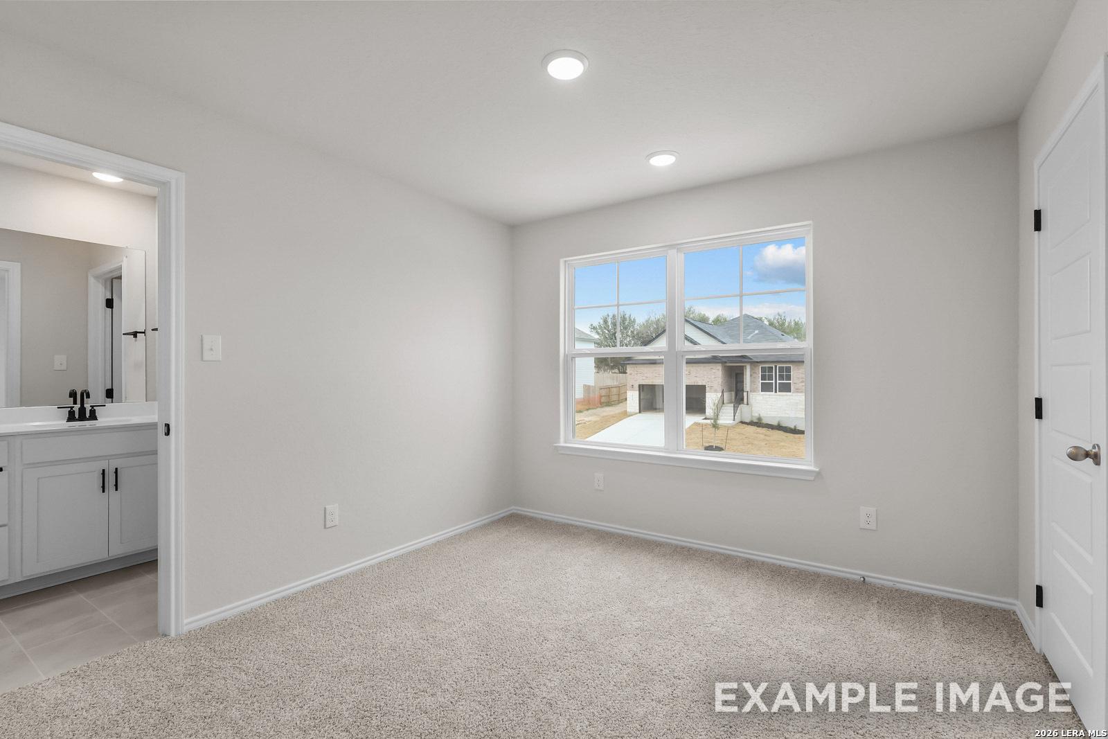 Bright bedroom with en-suite bathroom in The Sequoia C floor plan at Royal Crest, San Antonio, Texas.