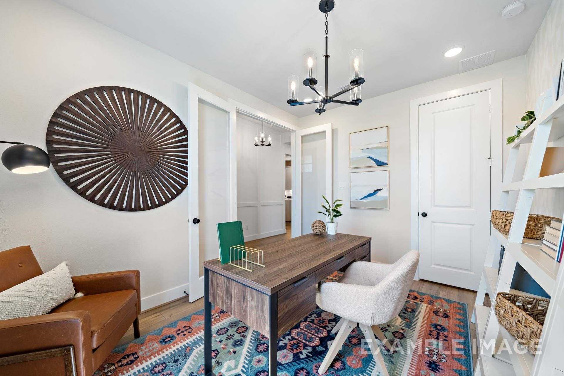 Modern home office with wooden desk, leather armchair, chandelier, wall art in Davidson Homes The Edward A, Lago Mar, Texas City