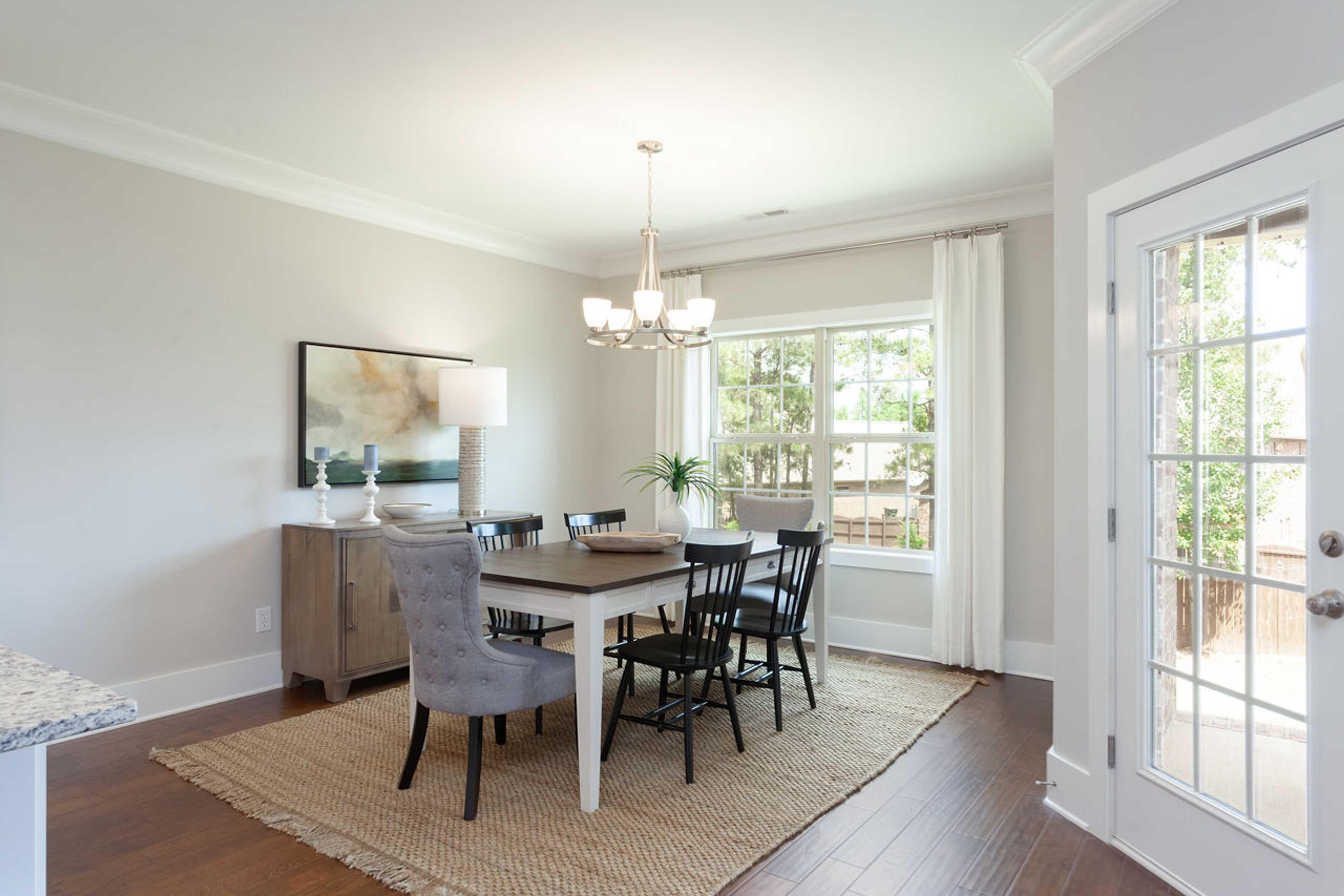 Elegant dining room at Laurenwood Preserve in Madison, Alabama with chandelier, hardwood floors, and French doors