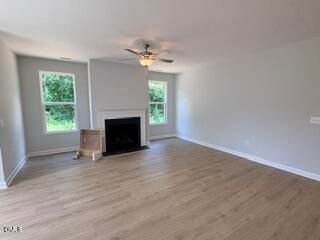 Spacious living room with fireplace and ceiling fan in The Daphne D floor plan at Woodland Crossing in Zebulon, NC.