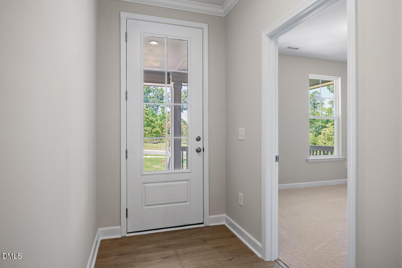 Bright foyer entrance with glass-paneled front door in The Chestnut floor plan by Davidson Homes in Montrose, Aberdeen, NC.