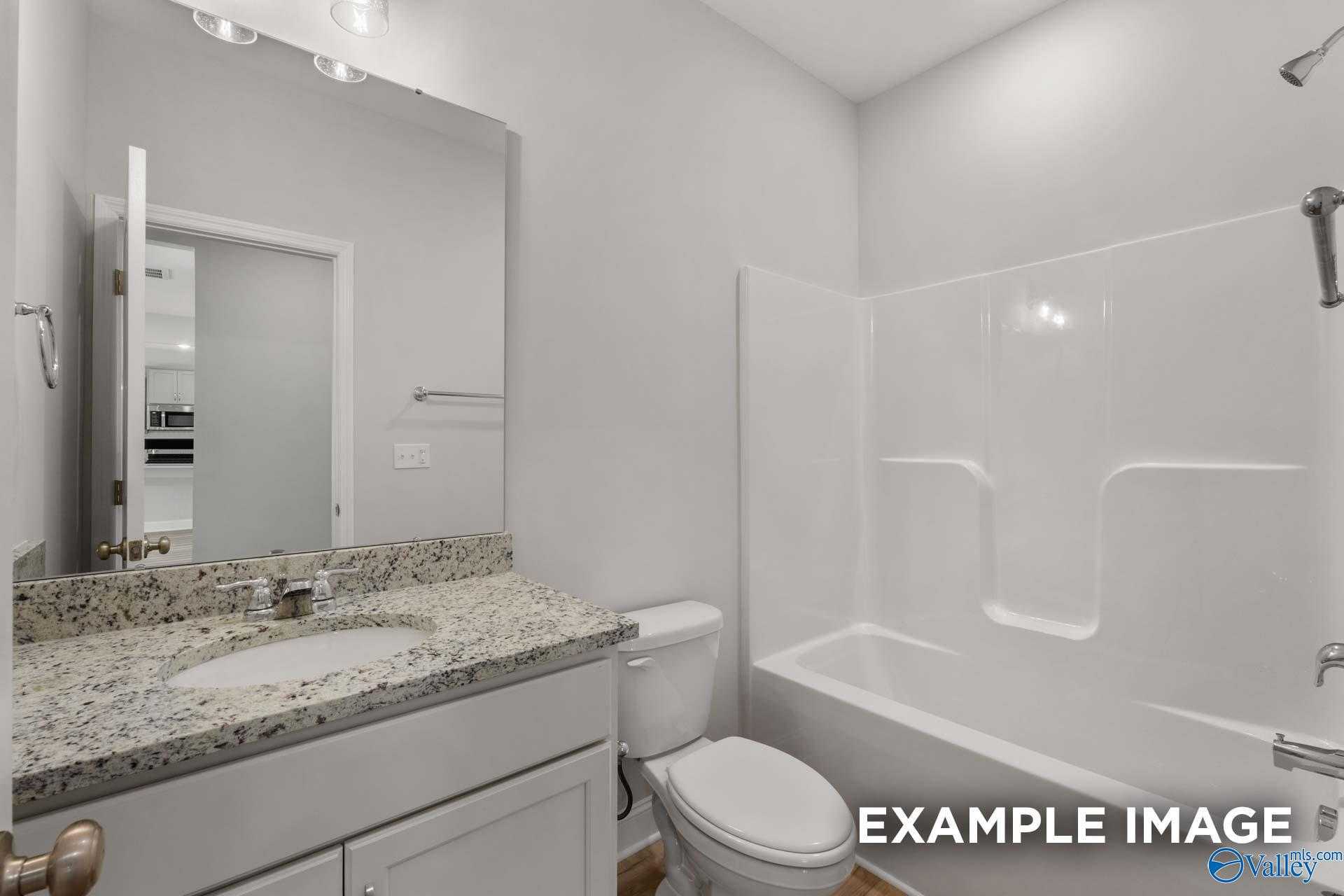 Modern master bathroom with granite vanity, freestanding tub, and walk-in shower in Davidson Homes The Shelby C, Meridianville, Alabama