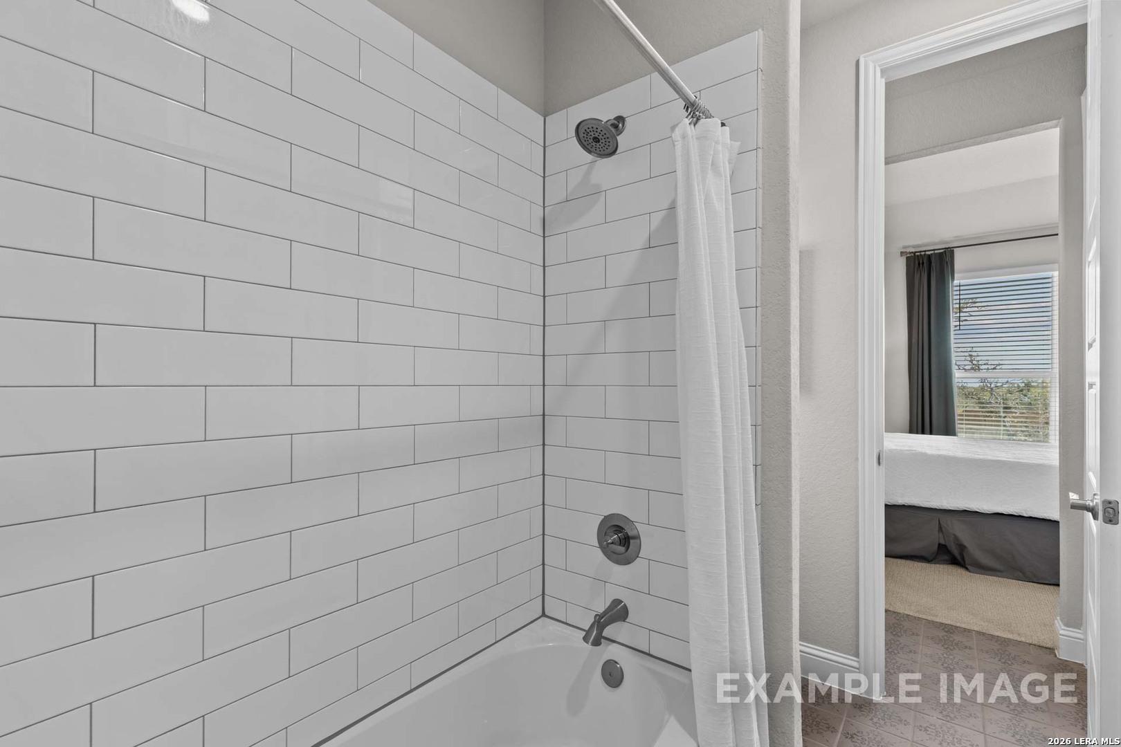 Modern bathroom with white subway tile shower-tub combo in The Garner C floor plan at The Reserve at Potranco Oaks.