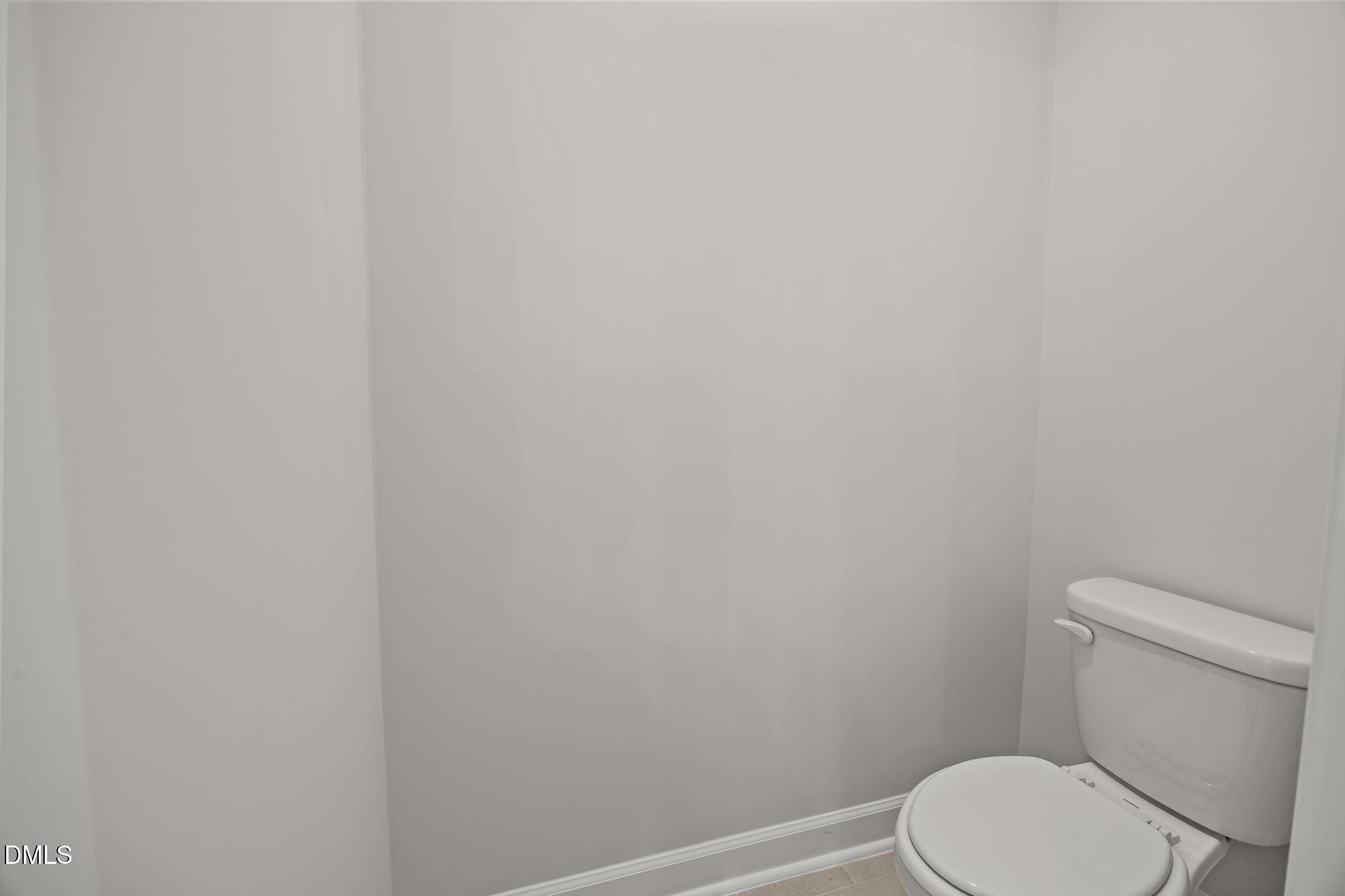 Modern white toilet in spacious powder room of 4-bedroom Davidson Homes Willow D, Wendell, NC