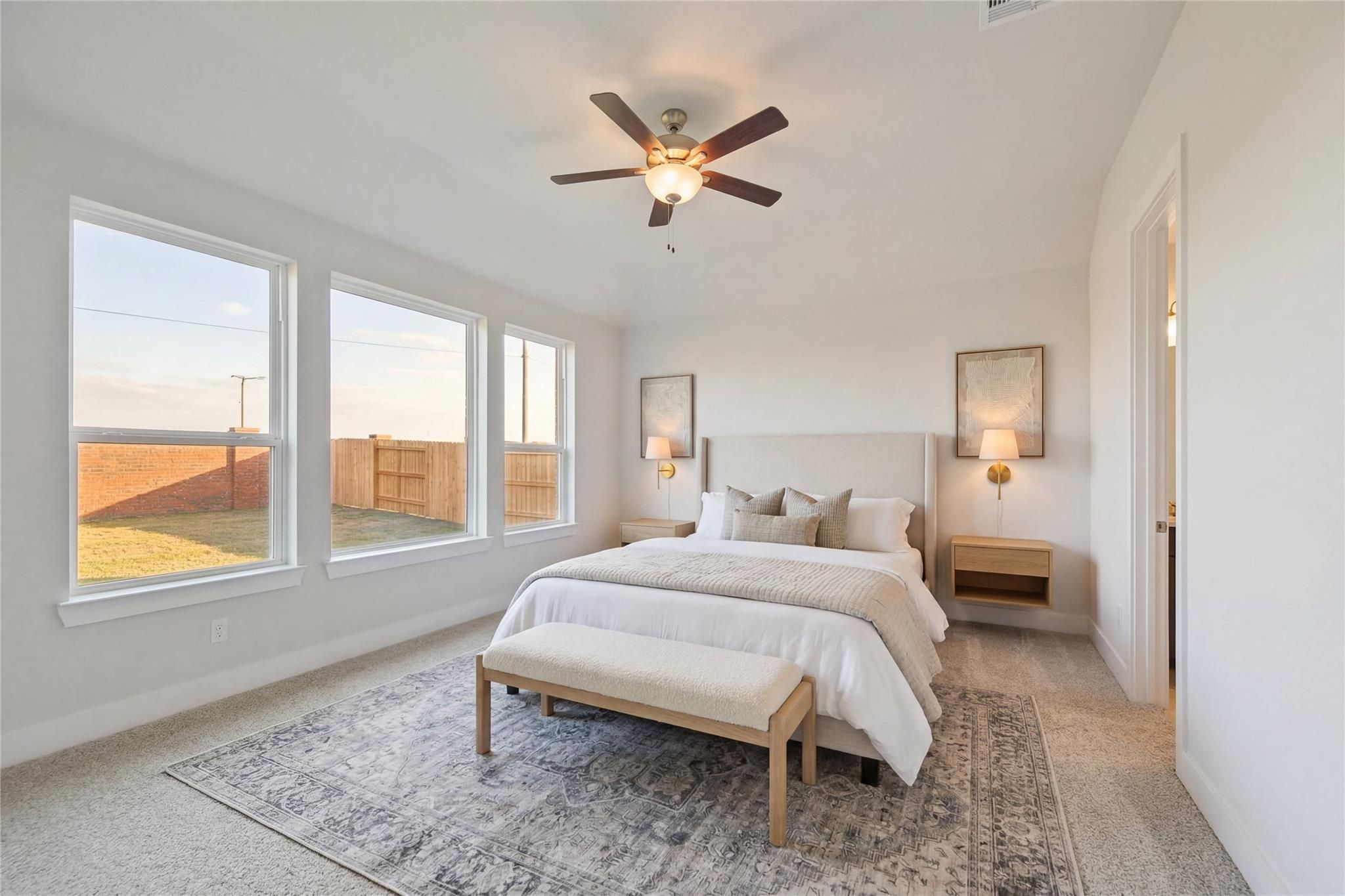 Bright master bedroom with king bed, ceiling fan, large windows overlooking backyard in Davidson Homes The Philip A, Texas City, Texas