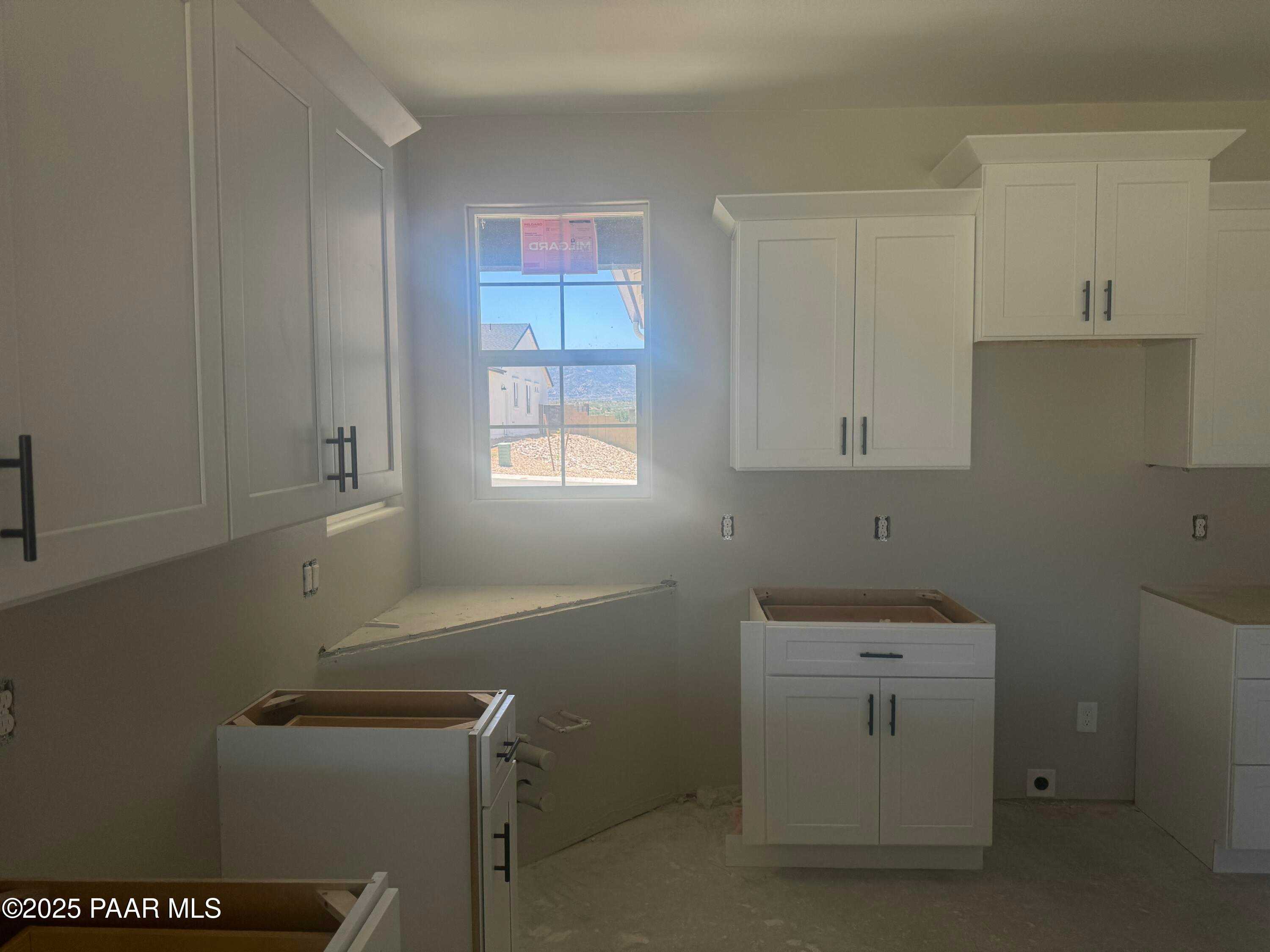 Modern white shaker kitchen cabinets under construction with sunny window in Davidson Homes Daybreak E, Prescott, AZ