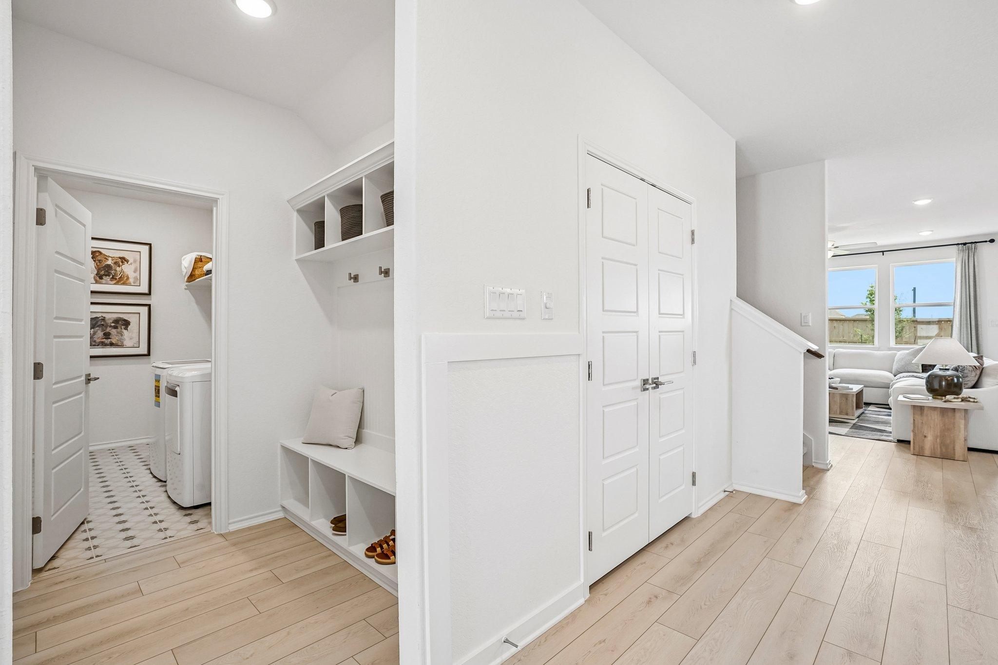 Mudroom with built-in bench and laundry room at Morgan Meadows in San Antonio by Davidson Homes.