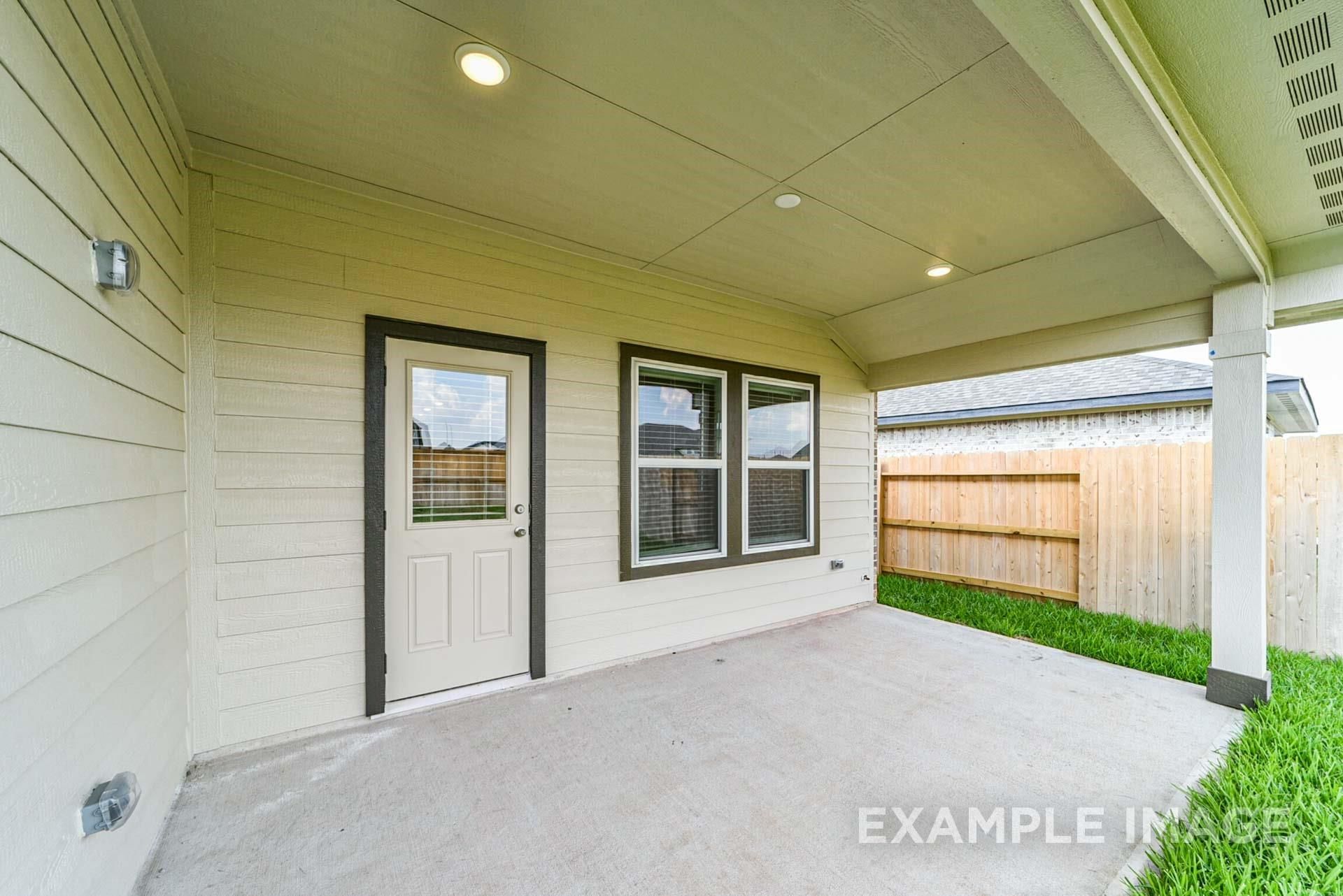 Covered concrete patio with recessed lighting at The Riviera A floor plan in Emberly, Beasley, Texas.
