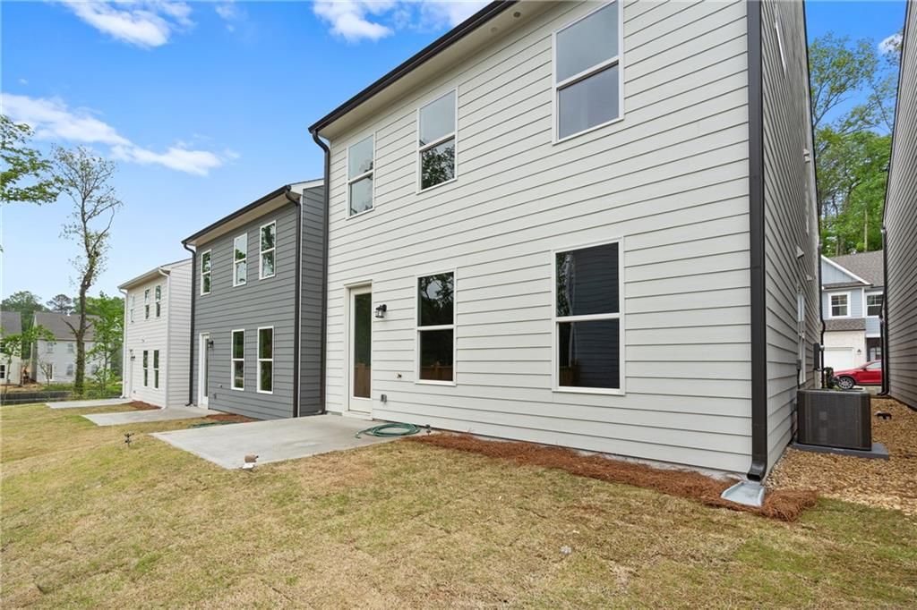 Modern two-story home exterior with gray siding, large windows, and grassy backyard in The Village at Shallowford, Kennesaw, Georgia