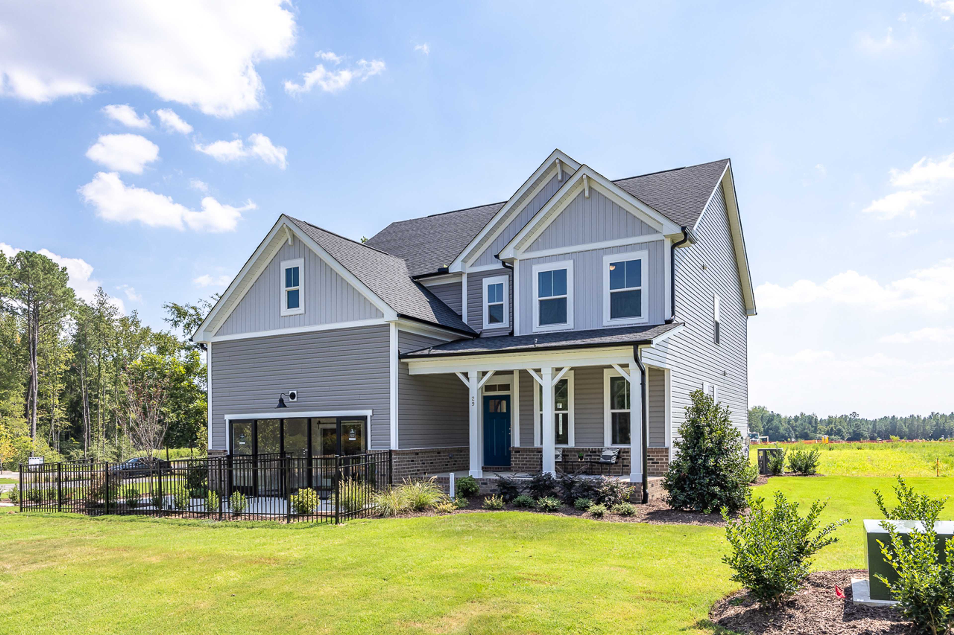Craftsman-style two-story home exterior at Wellers Knoll in Lillington NC with covered front porch and landscaped yard
