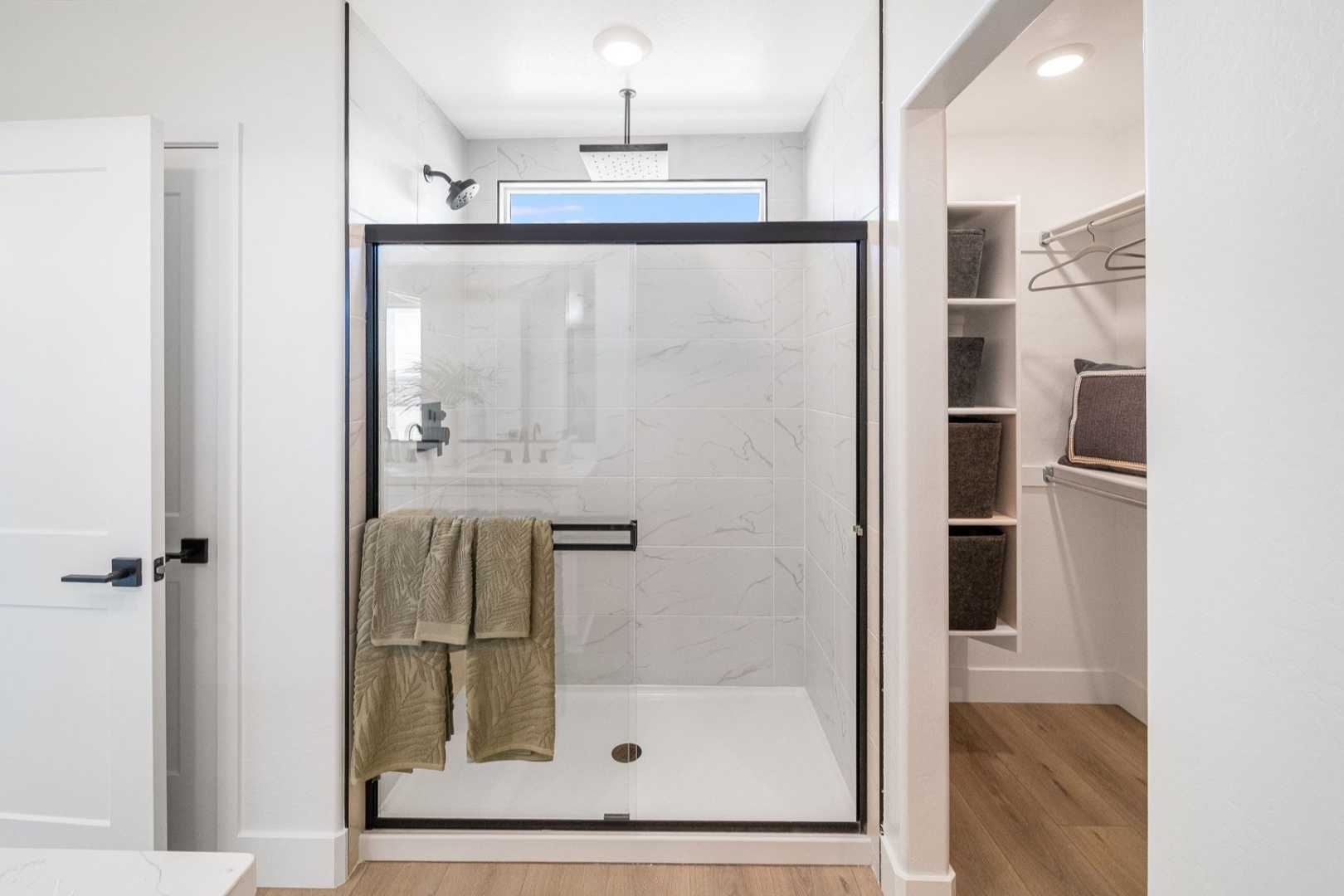 Modern master bathroom in The Wilmington with frameless glass shower, subway tile, and walk-in closet