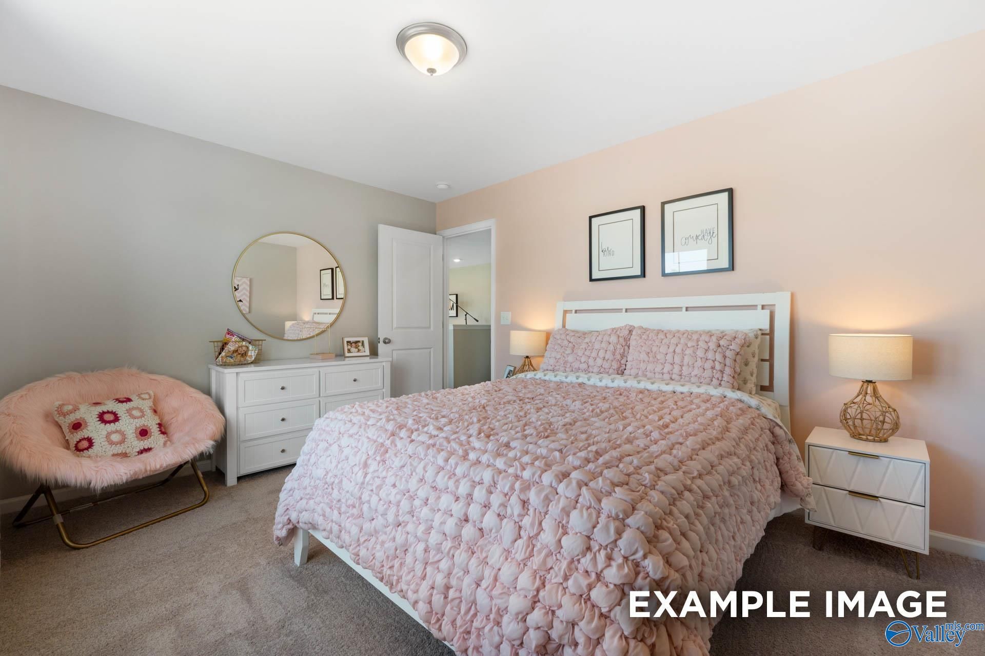 Serene master bedroom with blush pink tufted bed, accent chair, gold mirror in Davidson Homes The Stella, Evergreen Mill, Madison, AL