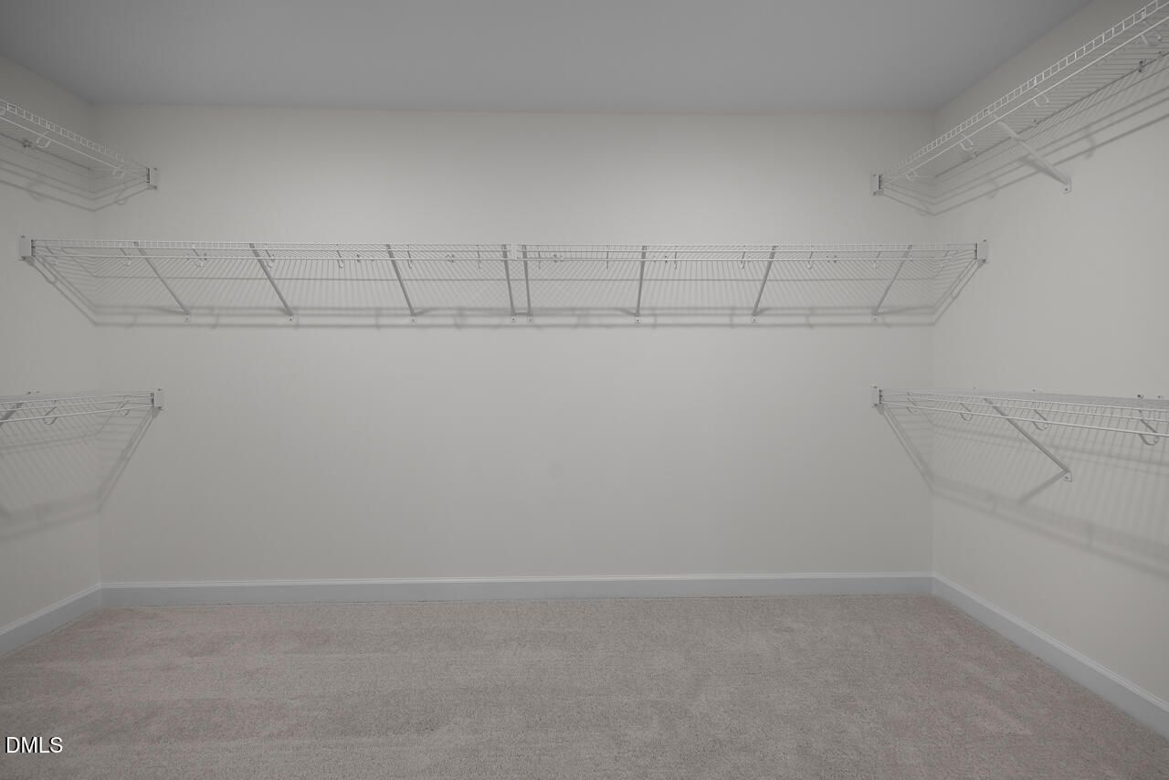 Walk-in closet with wire shelving in The Hickory II B floor plan at Wellers Knoll, Lillington, North Carolina.
