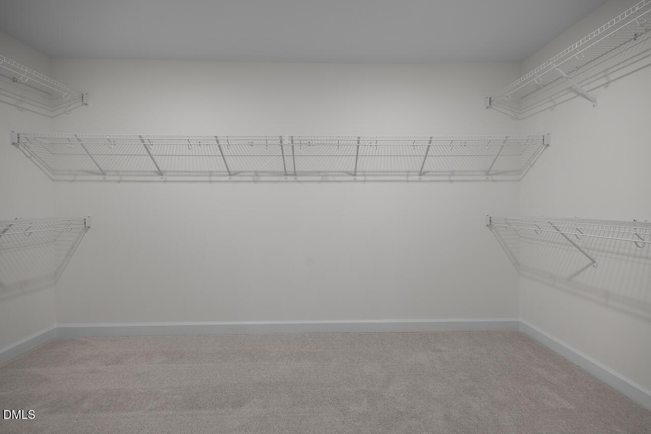 Walk-in closet with wire shelving in The Hickory II B floor plan at Wellers Knoll, Lillington, North Carolina.