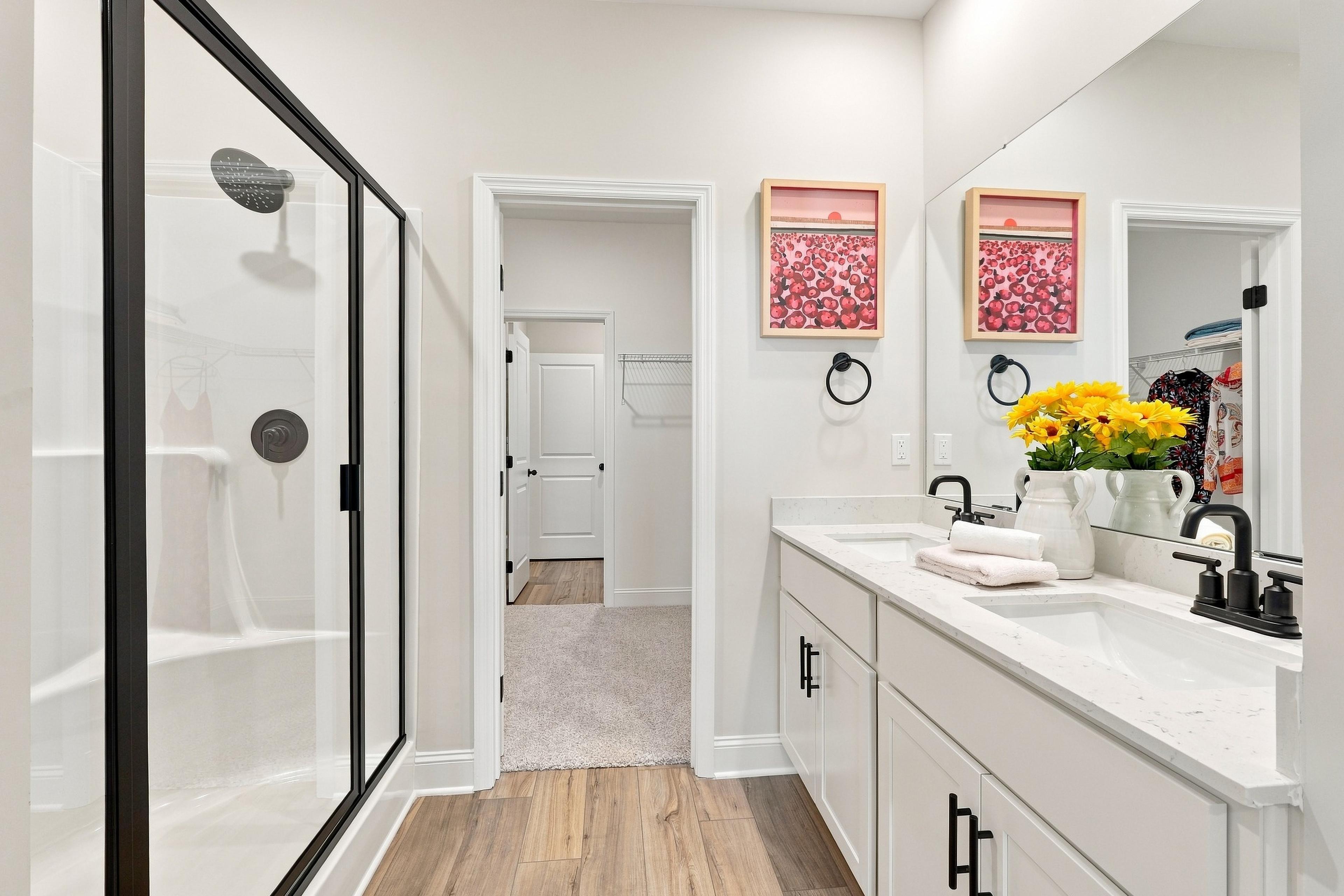 Primary bathroom at Bailey Park by Davidson Homes in Fayetteville, TN with double vanity, matte black fixtures and glass shower