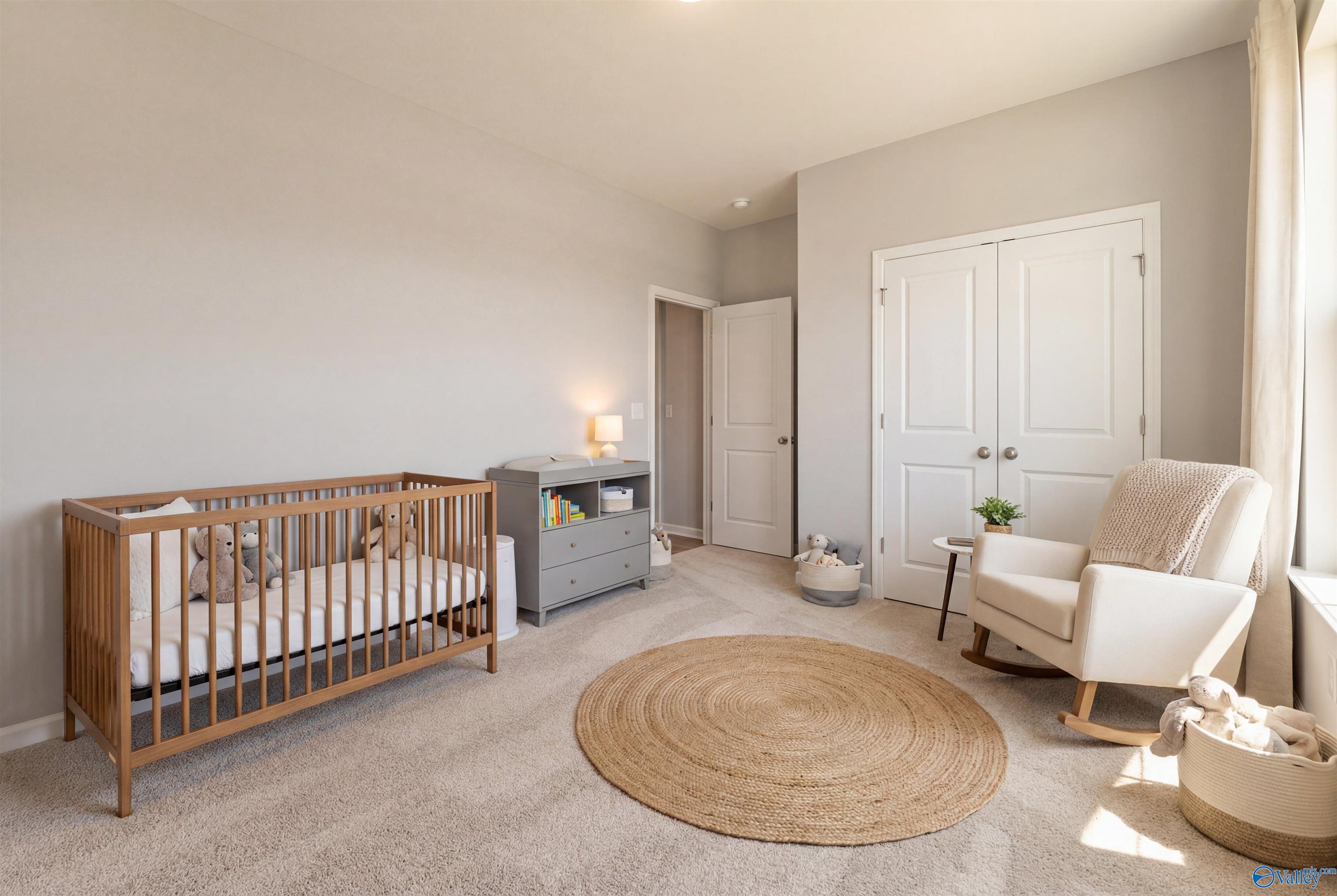 Cozy nursery featuring wooden crib, gray changing table, and white rocking chair in Davidson Homes The Phoenix, Hazel Green, Alabama