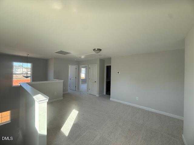 Spacious upstairs hallway with balcony railing and bedroom doors in Davidson Homes The Gavin B, Lillington, NC